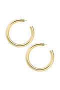 Gold hoop earrings on a light beige background