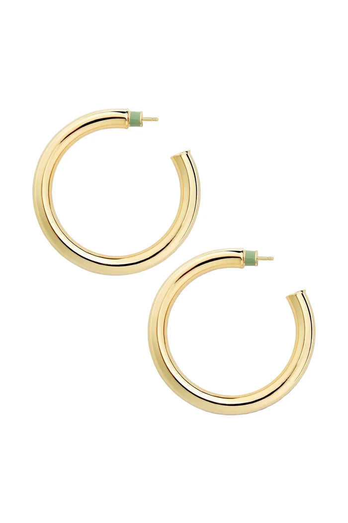 Gold hoop earrings on a light beige background