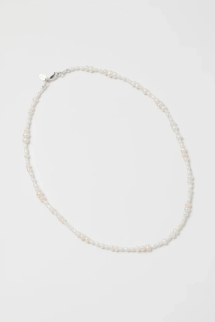 Pearl necklace on a light gray background