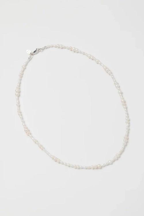 Pearl necklace on a light gray background