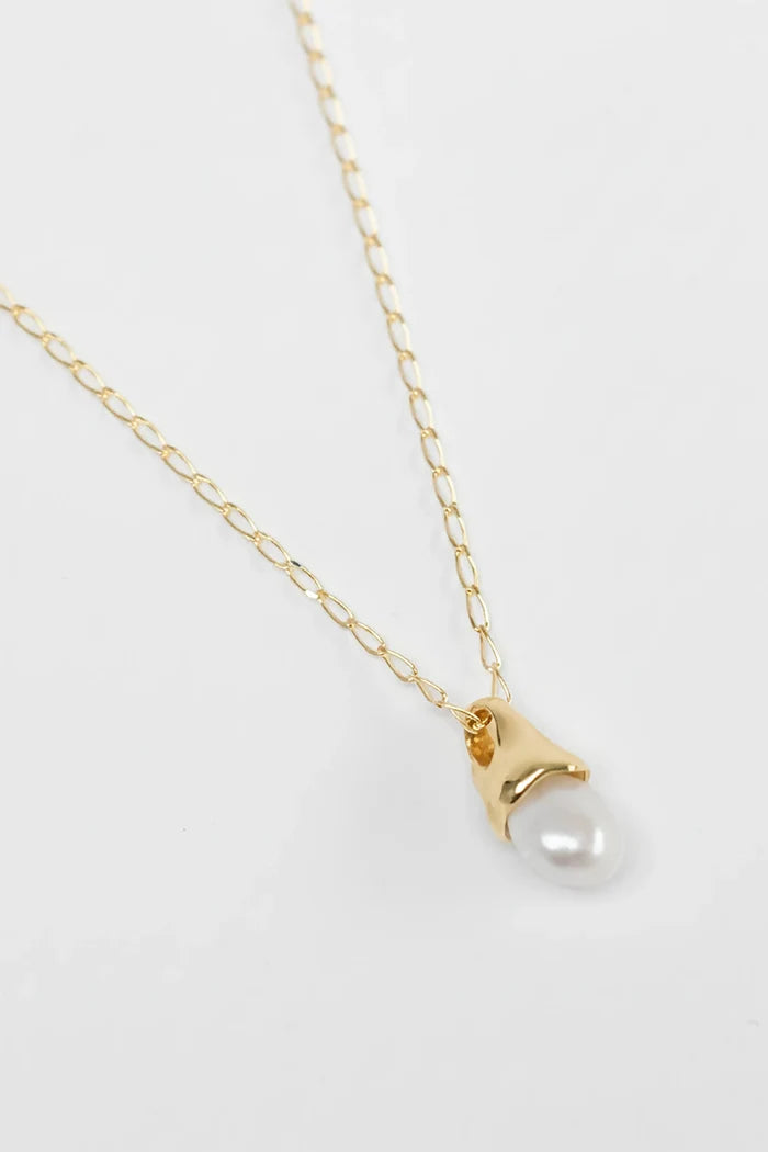 Gold necklace with a pearl pendant on a white background