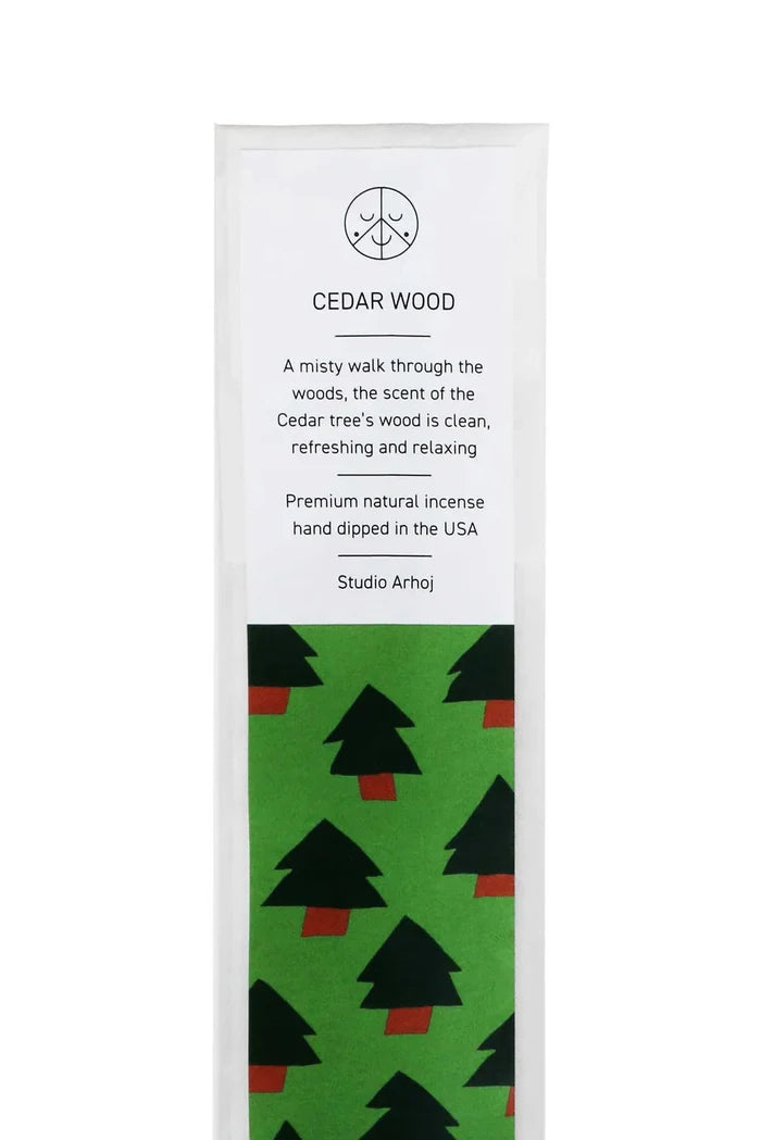 Cedar wood incense packaging with green tree pattern on a white background