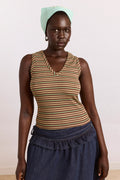 Woman wearing a striped tank top and blue skirt with a light green headscarf against a white background