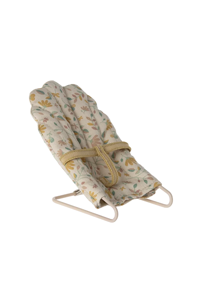 Floral-patterned mini baby bouncer with stand on a white background