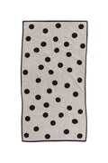White bath towel with black polka dots on white background