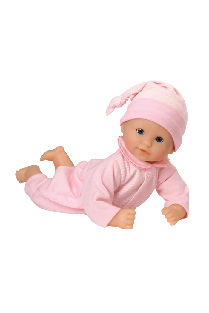 Baby doll in pink outfit and hat on a white background
