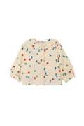 A cream-colored long-sleeve button-up shirt for toddlers, featuring a Peter Pan collar and an all-over colorful print of small characters and shapes, laid flat against a light gray background.