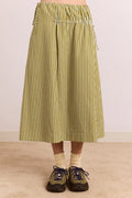 Person wearing a green and white striped skirt on a plain background