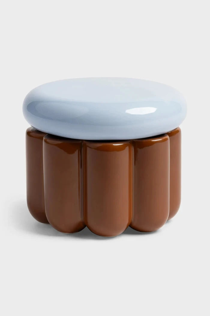 Jar with scalloped sides on white background. The body of the jar is brown and the lid is light blue.