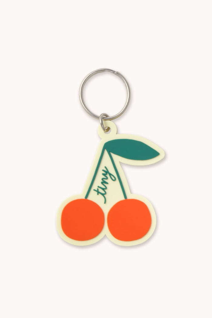Cherry-shaped keychain with a green stem on a white background