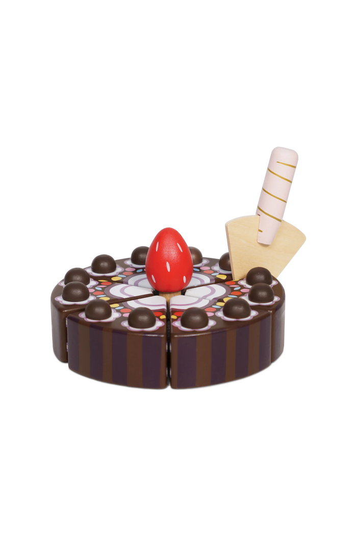 A wooden toy cake set with chocolate brown and white striped sides, decorated with chocolate candies, a red cherry on top, and a striped vanilla ice cream cone on a yellow base, isolated on a white background.