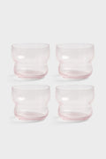 Four pink glass tumblers on a white background