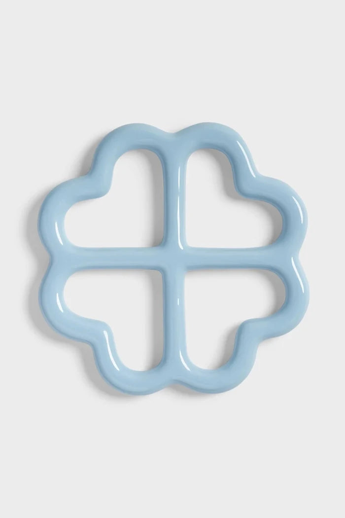 Clover shaped ceramic trivet on white background