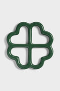 Green ceramic trivet shaped like a clover on a white background.