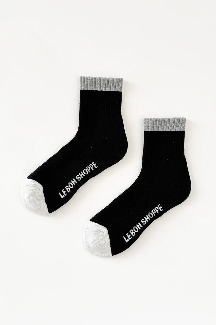 Black socks with 'Le Bon Shoppe' branding on a white background