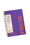 A purple spiral-bound daily planner labeled 'FOCUS'.
