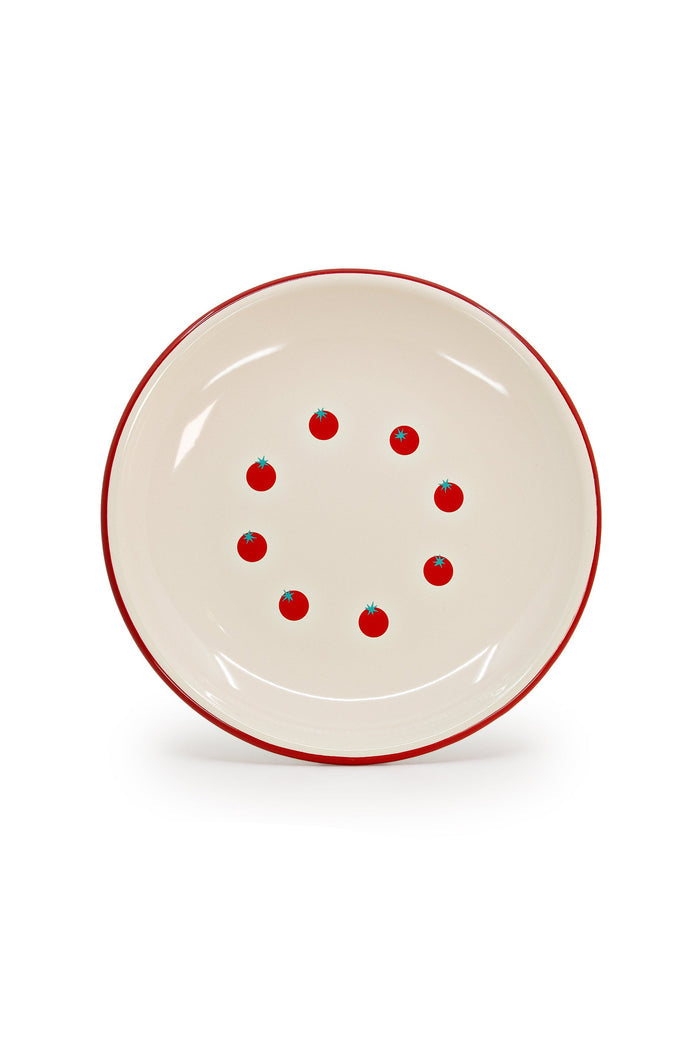 Cream enamelware plate with red rim and graphic tomato pattern.
