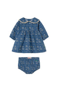 A baby girl's two-piece outfit set consisting of a long-sleeve smocked blouse and matching bloomers, both in a blue denim-like fabric with a white floral print and a cream beaded collar, shown on a plain off-white background.
