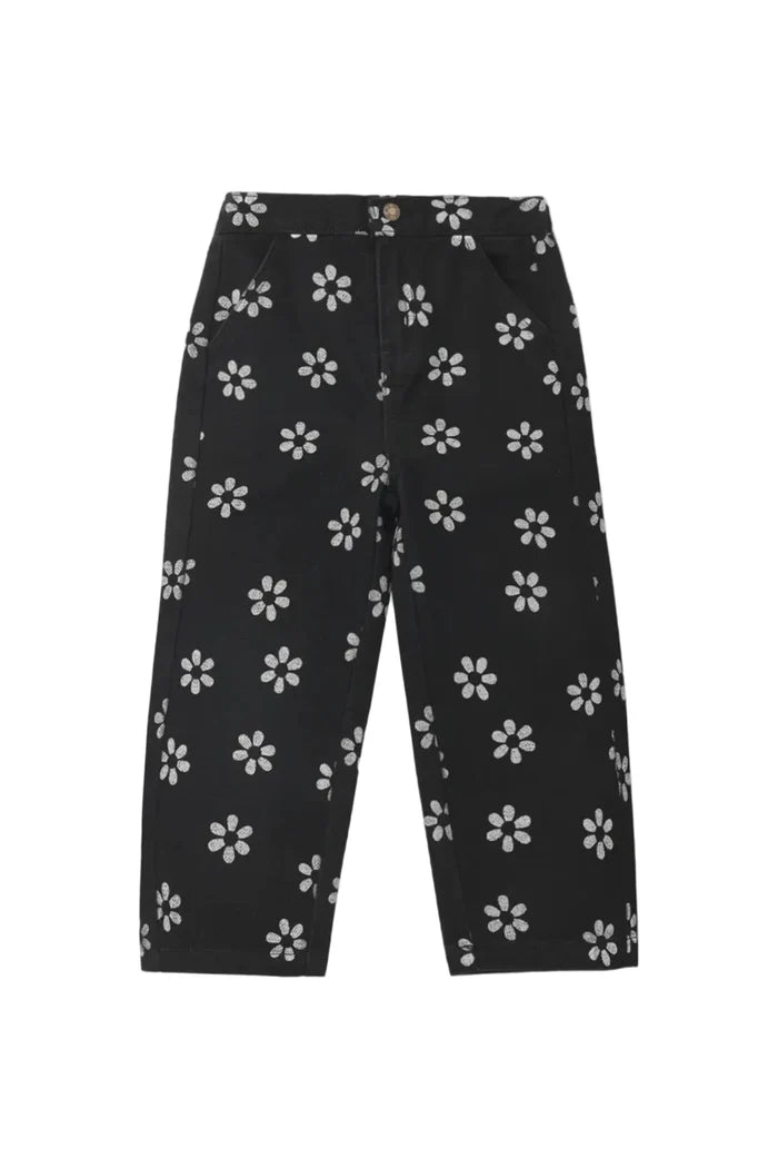 Black cropped pants with an all-over white daisy pattern, shown flat against a light gray background.