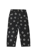 Black cropped pants with an all-over white daisy pattern, shown flat against a light gray background.