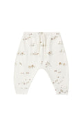 White baby pants with a small brown and beige animal print, featuring an elastic waistband and drawstring.