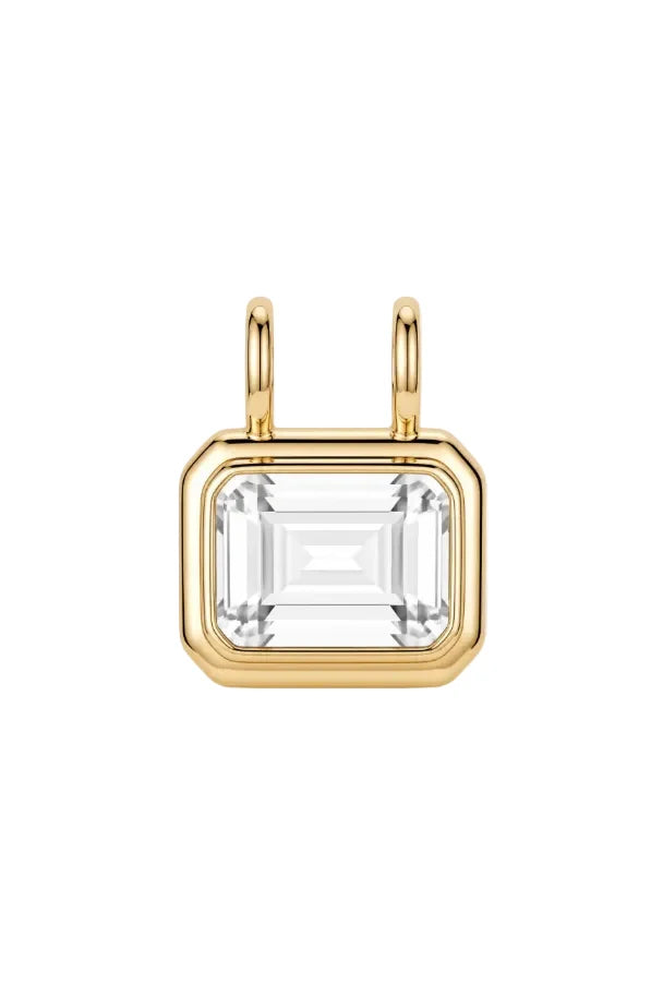 A gold pendant featuring a large rectangular clear baguette-cut gemstone in a gold bezel setting with two small gold loops at the top, shown on a clean white background.