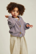 Child wearing a striped sweater and beige pants on a plain background