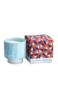 Light blue ceramic candle with a patterned box on a white background