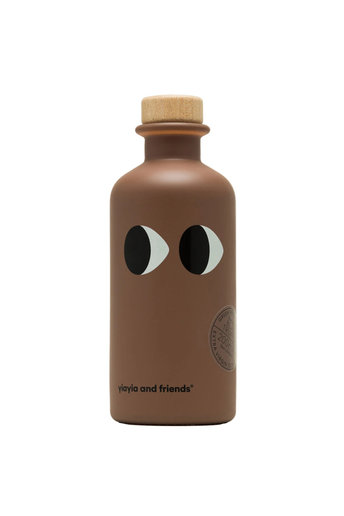 A bottle of extra virgin olive oil with black truffle flavor, branded Yiayia and Friends.