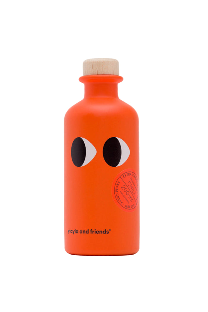 A 200 ml bottle of Yiayia and Friends extra virgin olive oil with chili peppers, featuring a cartoonish face on the label.