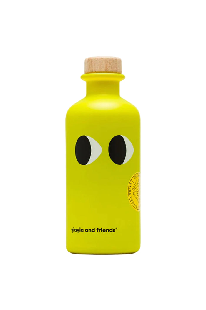 A yellow bottle of extra virgin olive oil branded 'yiayia and friends' with a face drawing on the bottle.