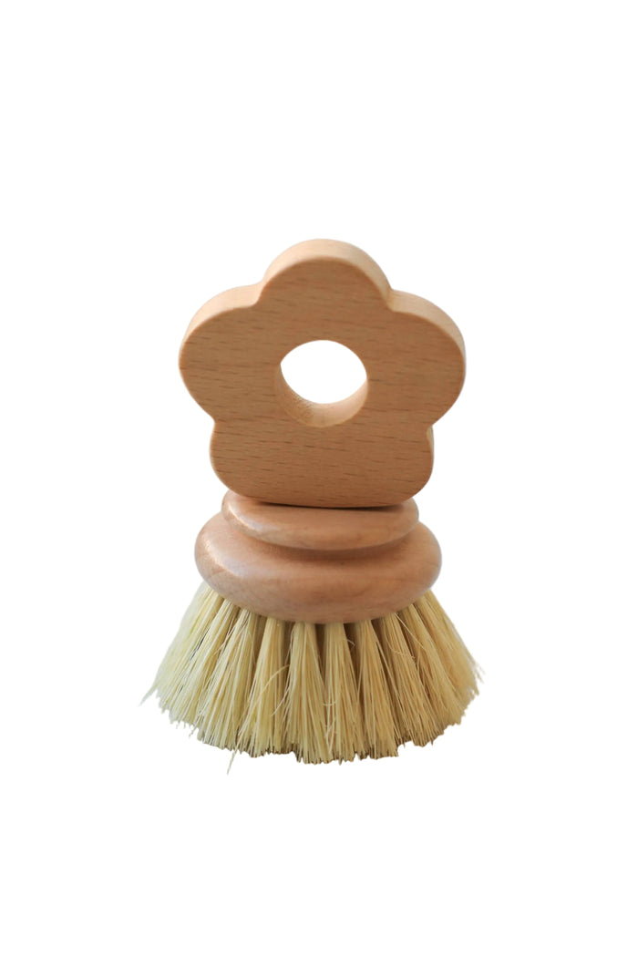 Wooden dish brush with a flower-shaped handle on a marble surface