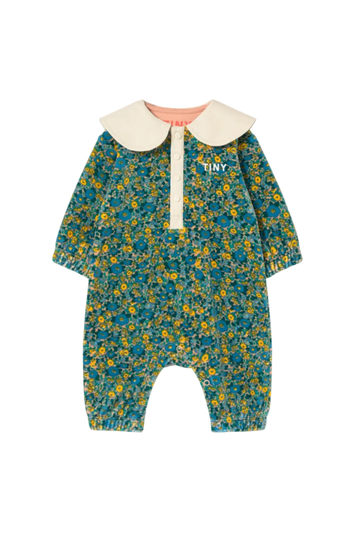 A baby long-sleeve romper with a blue and yellow floral pattern, featuring a cream-colored Peter Pan collar and a white zipper at the chest. The brand name 'TINY' is printed on the chest.