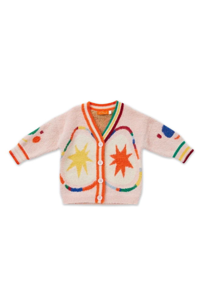 A fuzzy pink cardigan sweater for toddlers, featuring colorful knit patterns with starbursts, stripes, and heart shapes in orange, yellow, green, blue, and red. It has a V-neck, button closure, and striped cuffs.