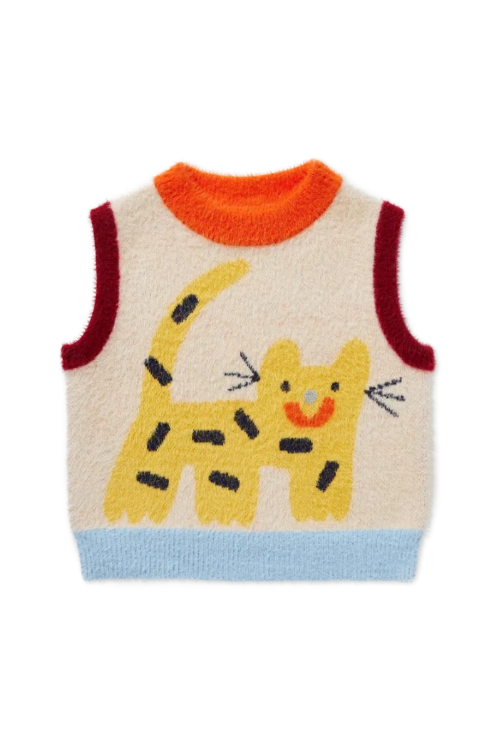 A sleeveless fuzzy knit sweater vest in cream with a colorful cat graphic. The vest features an orange crew neck, dark red armholes, a light blue hem, and a yellow cat design with black stripes on the front.
