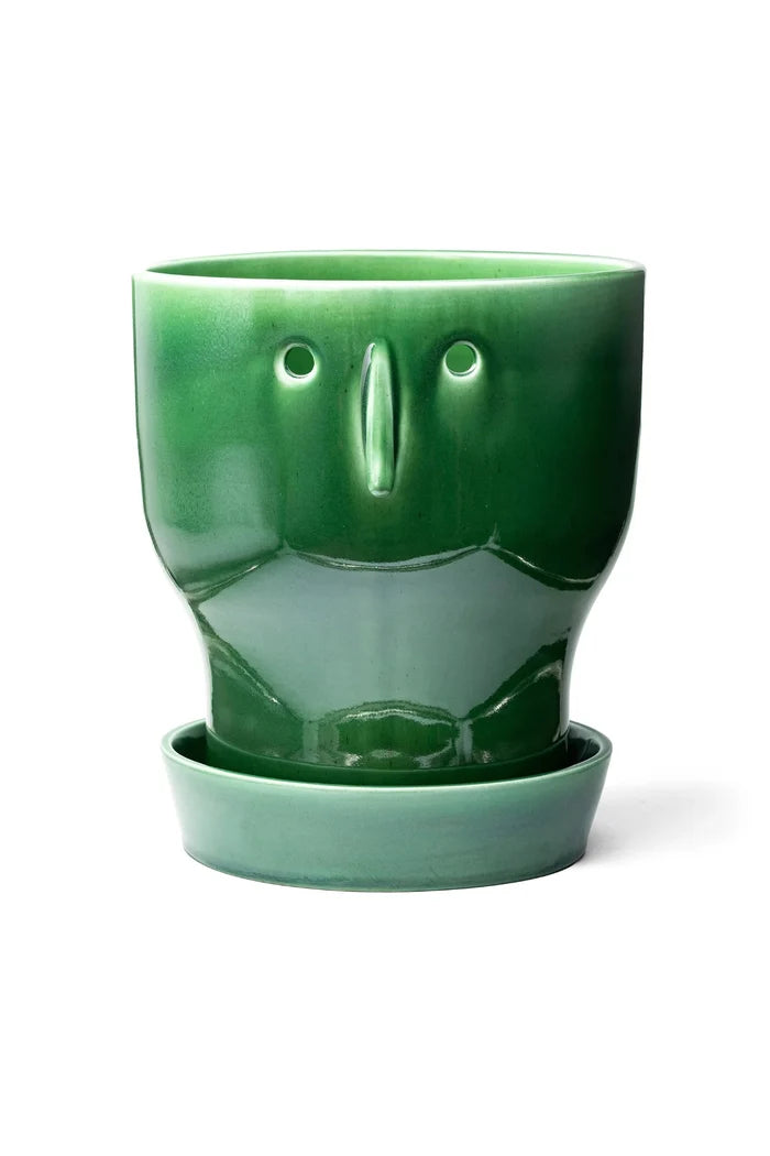 Green ceramic face planter with a matching saucer on a white background
