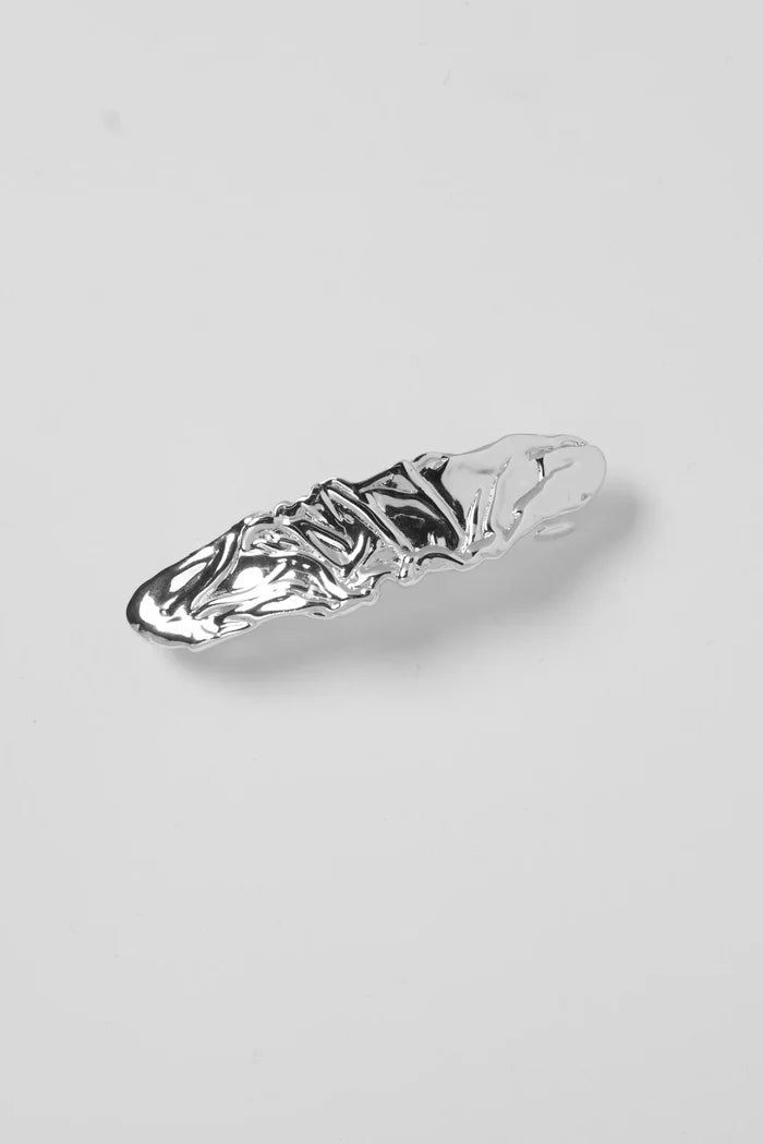 Silver hair clip on a light gray background