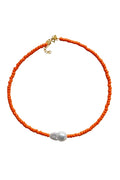 Orange beaded necklace with a pearl pendant on a light gray background