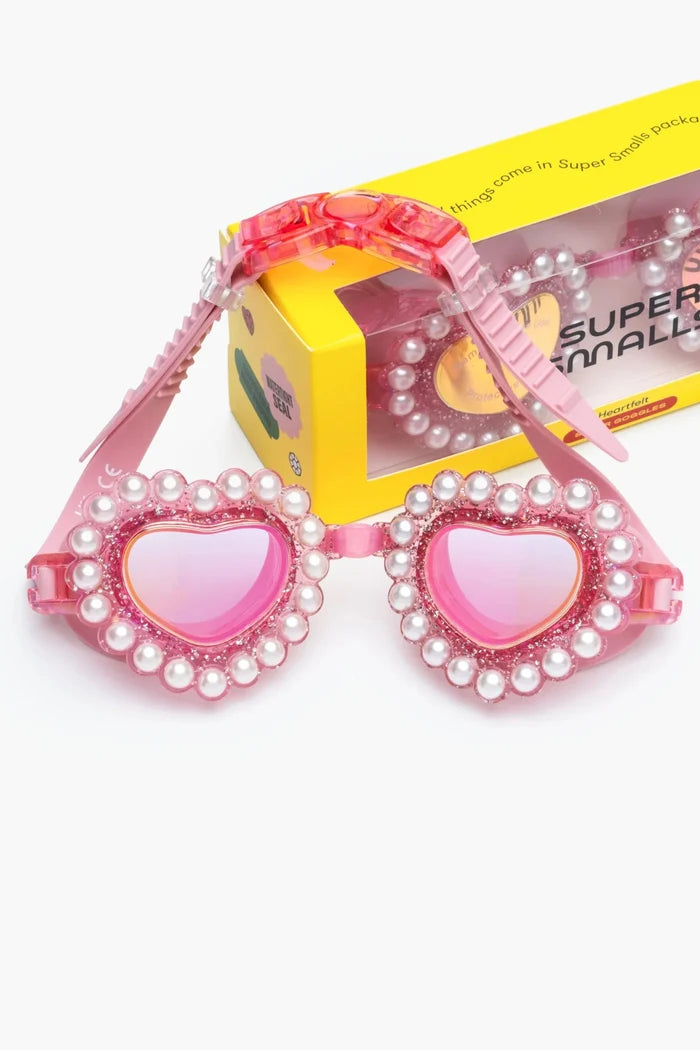 Pink heart-shaped sunglasses with pearl details on a white background