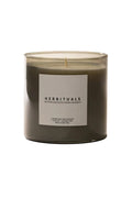 Candle with a 'Herbituals' label on a light background