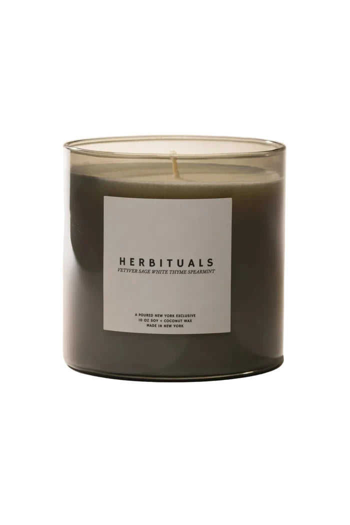 Candle with a 'Herbituals' label on a light background
