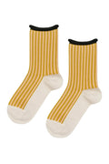 A pair of crew socks with mustard yellow and white vertical stripes, featuring solid white toes and heels, and black ribbed cuffs.