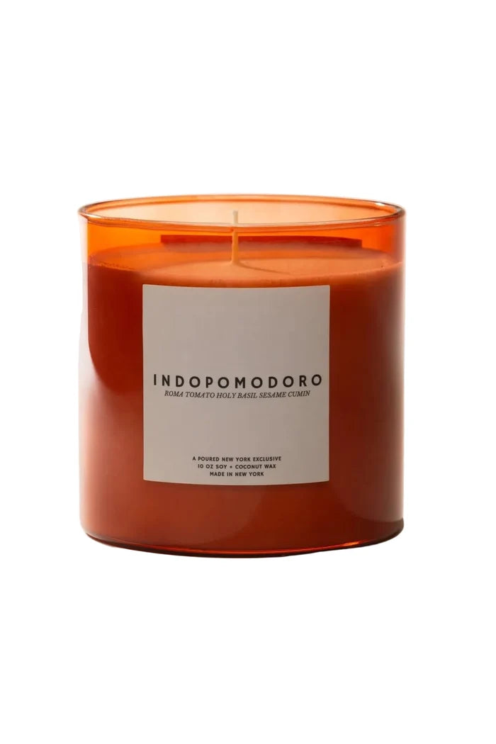 Orange candle with a white label on a beige background