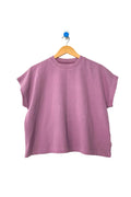 Purple t-shirt on a wooden hanger against a white background