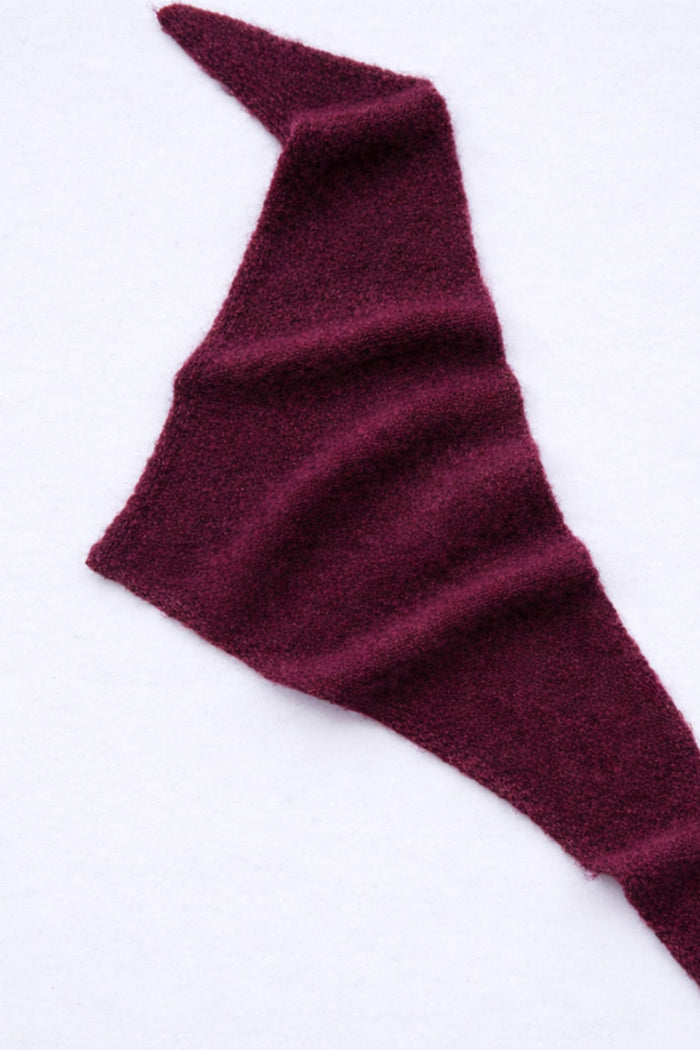 Maroon knitted scarf on a white background
