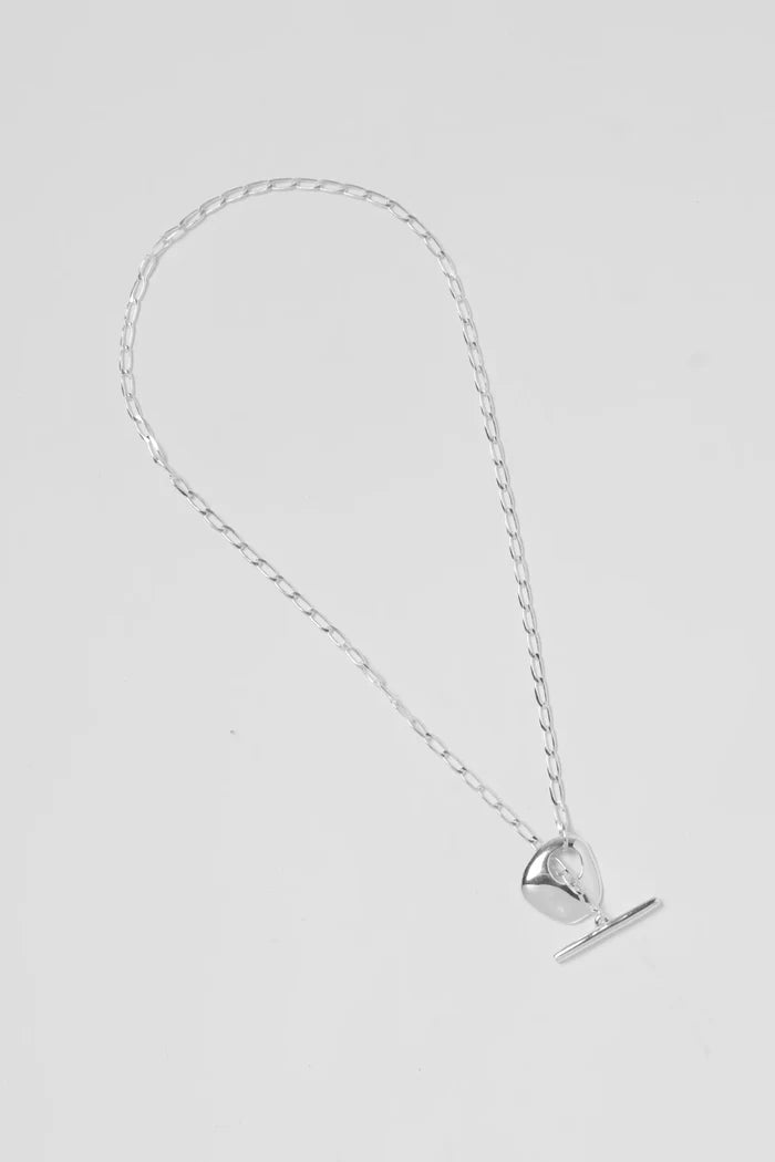 Silver necklace with a petal-shaped pendant and bar on a light gray background