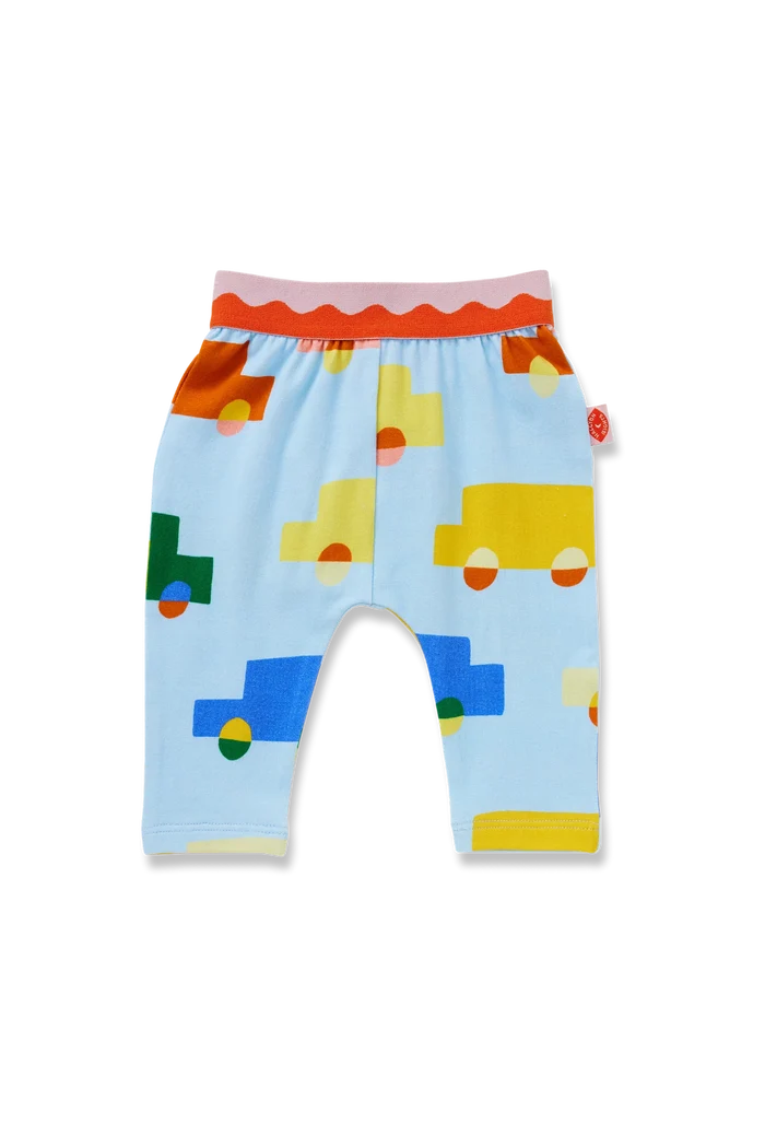 Light blue baby pants with a colorful geometric truck pattern, featuring an orange and pink elastic waistband, photographed on a white background.