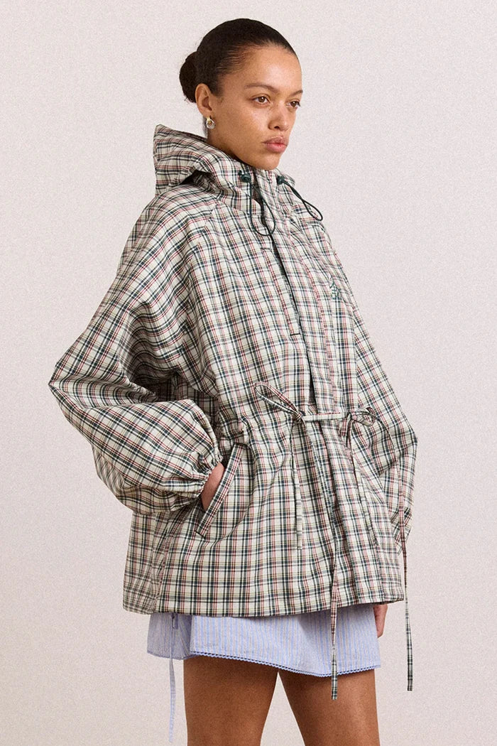 Person wearing a plaid jacket on a plain background