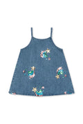 A blue denim baby dress with thin straps and colorful sequined mermaid and star motifs, displayed flat against a white background.