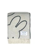 Gray blanket with black bunny design and brand label on a white background